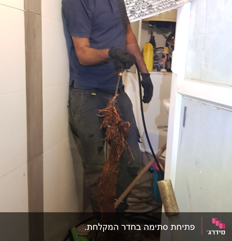 אינסטלטור מחזיק צינור עם שורשים סתומים